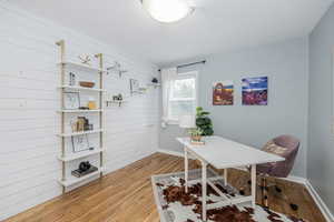 Office space featuring wooden walls and light wood-style floors