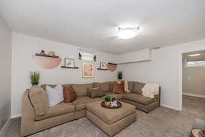 Carpeted living room featuring baseboards and a textured ceiling