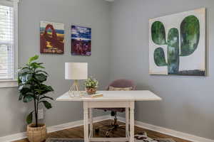 Home office with wood finished floors and baseboards