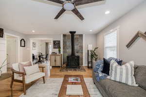 Living area featuring a wood stove, wood finished floors, recessed lighting, and a ceiling fan