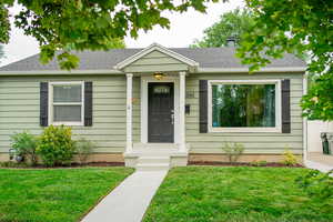 View of front facade featuring a front yard and a shingled roof