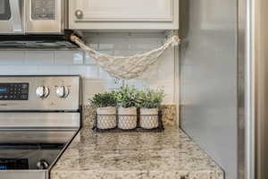Kitchen view of stainless steel appliances and backsplash