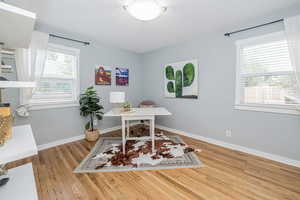 Office area with light wood-style floors and plenty of natural light