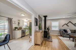 Living room with a wood stove and light wood-style flooring