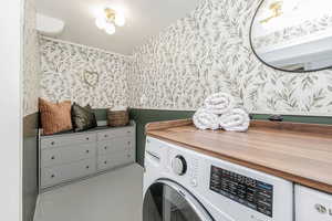 Laundry area featuring wallpapered walls