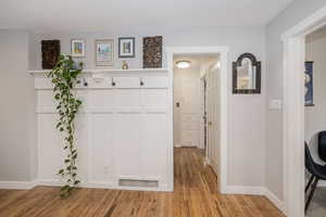 Corridor featuring light wood-style flooring and baseboards