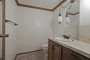 Half bath featuring vanity and crown molding