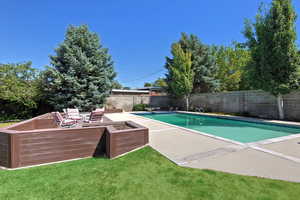 View of swimming pool featuring a patio, a fenced backyard, and a diving board