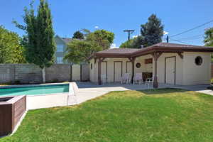 Rear view of property featuring a patio, a gate, and a shingled roof
