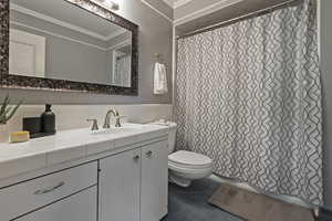 Full bathroom featuring vanity, tile walls, and crown molding