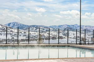 Snow covered pool featuring a mountain view and an outdoor pool