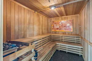 Sauna / steam room with wooden ceiling, wood walls, and tile patterned floors