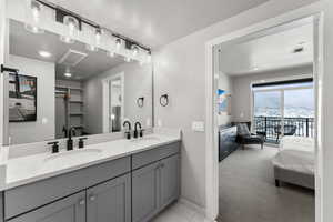 Ensuite bathroom featuring double vanity and a walk in closet