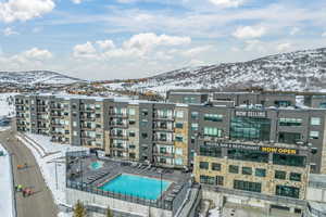 Snow covered building featuring a community pool and a mountain view