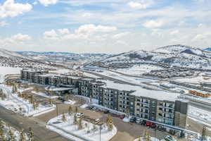 Snowy aerial view with a view of apartment building / complex and a mountain view