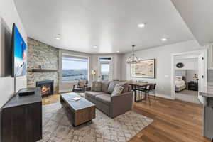 Living area featuring wood finished floors, a chandelier, a fireplace, and recessed lighting