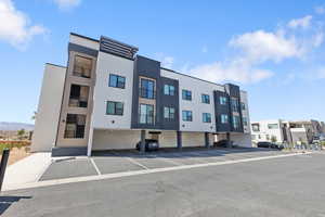 View of property with covered and uncovered parking