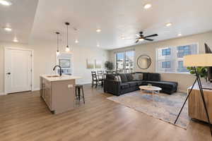 Living room with light wood finished floors, recessed lighting, and a textured ceiling
