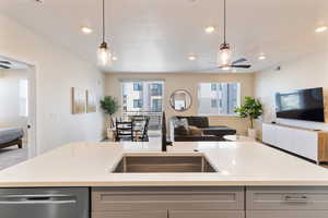 Kitchen with open floor plan, gray cabinetry, healthy amount of natural light, stainless steel dishwasher, and recessed lighting