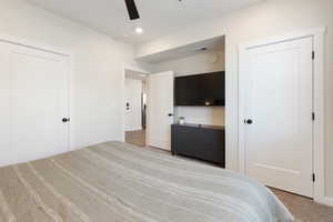 Bedroom featuring light colored carpet, a ceiling fan, and recessed lighting