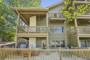Rear view of house with board and batten siding and a balcony