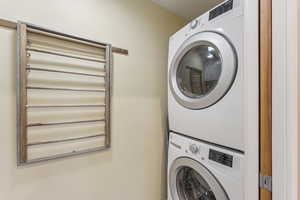 Washroom featuring stacked washer / drying machine