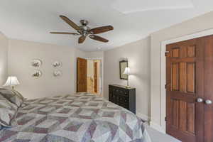 Carpeted bedroom featuring a ceiling fan and baseboards