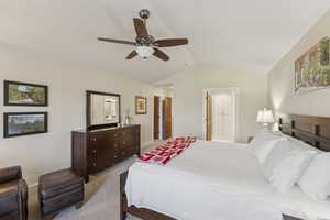 Bedroom featuring vaulted ceiling, carpet, and ceiling fan