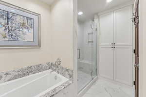 Bathroom with a marble finish shower, a bath, light marble finish flooring, and recessed lighting