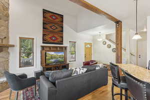 Living area with light wood-style flooring, stairway, and a towering ceiling