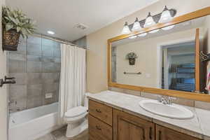 Full bath featuring shower / bath combination with curtain, vanity, light tile patterned floors, and recessed lighting