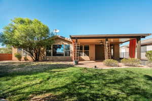 Rear view of property featuring a ceiling fan, stucco siding, and a patio