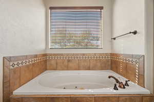 Full bathroom with a whirlpool tub and plenty of natural light
