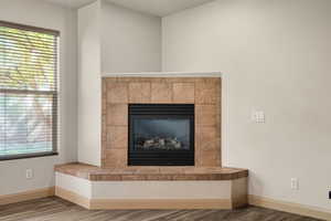 Detailed view of a tiled fireplace and wood finished floors