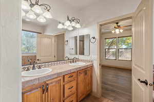 Full bathroom featuring double vanity, plenty of natural light, and a ceiling fan