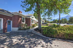 View of side of property featuring brick siding, a chimney, and a mountain view