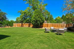 Fenced backyard with an outdoor living space with a fire pit and a patio area