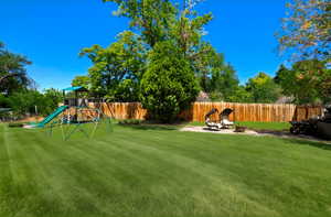 Fenced backyard with a patio area and a playground