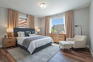 Bedroom with multiple windows and dark wood finished floors