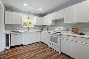 Kitchen with white cabinets, white appliances, dark wood finished floors, pendant lighting, and recessed lighting