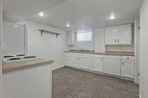 Kitchen featuring white cabinetry, white appliances, light countertops, open shelves, and recessed lighting
