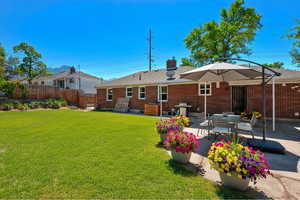 Back of house with a patio area, a chimney, and brick siding