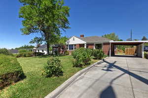 Ranch-style home with concrete driveway, brick siding, a chimney, and a shingled roof