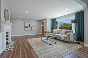 Living area with dark wood finished floors, recessed lighting, a fireplace with flush hearth, and a mountain view