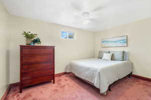 Bedroom featuring a textured ceiling, light colored carpet, and ceiling fan