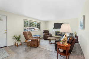 Living area featuring a fireplace and carpet flooring
