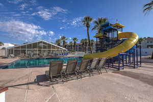 Community pool featuring a water slide and a patio area