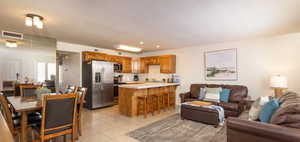 Kitchen featuring light countertops, brown cabinets, and open floor plan