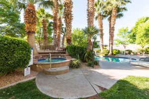 Community pool with a patio and a hot tub