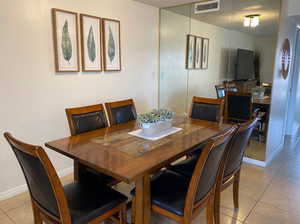Dining space featuring light tile patterned floors and baseboards